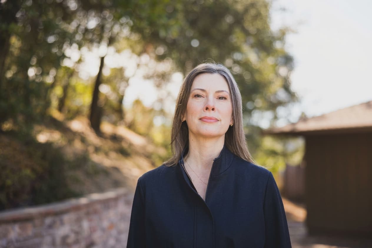 Kathleen Defever standing outdoors on a wooded Tiburon hillside